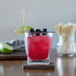 A drink in a glass with a HAY! wheat straw and fruit.