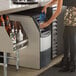 A woman pouring water into a Scotsman undercounter ice machine.