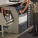 A woman pouring water into a Scotsman undercounter ice machine on a counter.