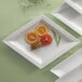 A CAC white porcelain narrow rim serving platter with sliced oranges on it.