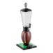 A beverage dispenser designed to resemble a football on a green base with a clear tube and spigot.