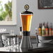 A Beer Tubes carbon conic beer tower on a table with two glasses of beer.