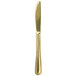 A Walco Colgate gold stainless steel dinner knife with a long blade.