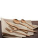 A set of Walco rose gold stainless steel table forks on a napkin.