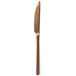 A close up of a Walco Rose Gold Stainless Steel Dinner Knife with a long blade and a metal handle.