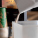 A coffee cup on a counter with a bag of HEATH Cappuccino Mix in it.