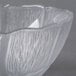 A Carlisle clear polycarbonate bowl with a wavy design.