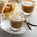 A white mug of UPOURIA Sugar Free French Vanilla Cappuccino on a white plate.