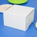 A white cake box on a blue surface.