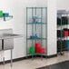 A green Regency metal pentagon shelf in a school kitchen.