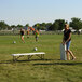 A white Lifetime 5' Bi-Fold Bench with a gray steel frame on a grassy field.