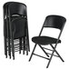 a stack of black folding chairs