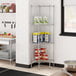 A metal Regency wire corner shelf kit in a kitchen with cans of food on it.