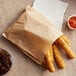 A Carnival King Kraft sandwich bag filled with fried food next to a drink and brown liquid.