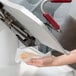 A person using a Berkel automatic meat slicer to slice meat.