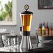 A stainless steel Beer Tube ice tube in a Beer Tube on a table with glasses.