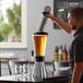 A man pouring beer into a glass from a stainless steel Beer Tube.