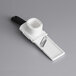 A close-up of a white OXO garlic slicer with a black handle.