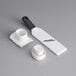 A white plastic OXO Good Grips garlic slicer handle.