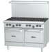 A stainless steel U.S. Range commercial gas range with black knobs and two storage bases.