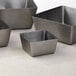 Three American Metalcraft stainless steel square bowls on a table.