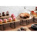 A table with cupcakes and cakes displayed under a clear dome cover.