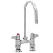 A chrome Equip by T&S deck-mounted faucet with two gooseneck spouts and lever handles.