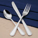 A Libbey stainless steel tablespoon and fork on a blue napkin.