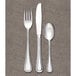 A Libbey stainless steel round bowl soup spoon on a gray surface.