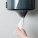 A person using Merfin 2-ply center pull paper towels in a paper towel dispenser.