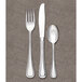 A Libbey stainless steel dinner fork on a gray surface.