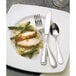 A plate of food with a Libbey stainless steel dinner fork and spoon.