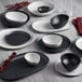 A dark gray irregular round melamine bowl on a white table.