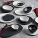 A dark gray GET Enterprises Riverstone melamine bowl on a white plate.