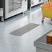 A 12-inch by 36-inch stainless steel floor trough with a grate, installed in a commercial kitchen floor.