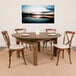 A Flash Furniture round farm table with plates on it and chairs with cushions around it.