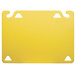A yellow plastic cutting board with two holes.