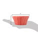 A hand holding a CAC red floral ramekin.