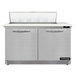 A stainless steel Continental Refrigerator with two doors open over a cutting top.