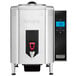 A silver and black Waring hot water boiler with a red handle.