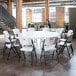 A white Lifetime round folding table with white folding chairs.