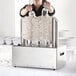 A woman using a Noble Glass Genie electric glass polisher with eight brushes.