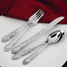 A close-up of a Walco Patrician stainless steel dessert spoon and knife on a white plate.