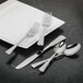 A white plate with a Walco Chanteclair stainless steel serving spoon on it.