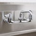 A chrome Equip by T&S wall mounted faucet with lever handles and a 6 1/8" swing spout.