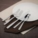 A white plate with a Walco stainless steel salad fork on it.