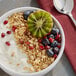 A bowl of yogurt with kiwi, grapes, and Bob's Red Mill Honey Oat Granola.