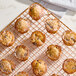 A batch of small muffins dusted with powdered sugar on a cooling rack.