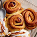 A glass dish filled with cinnamon rolls made with Bob's Red Mill Gluten-Free 1-to-1 Baking Flour with a spoon.