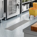 A 12-inch by 54-inch stainless steel floor trough with a grate, designed for commercial kitchen drainage.